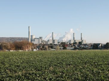 Gröna åkrar med fabrik