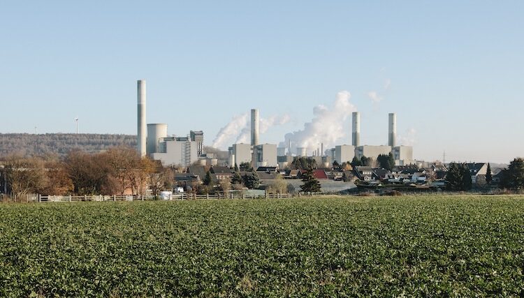 Gröna åkrar med fabrik