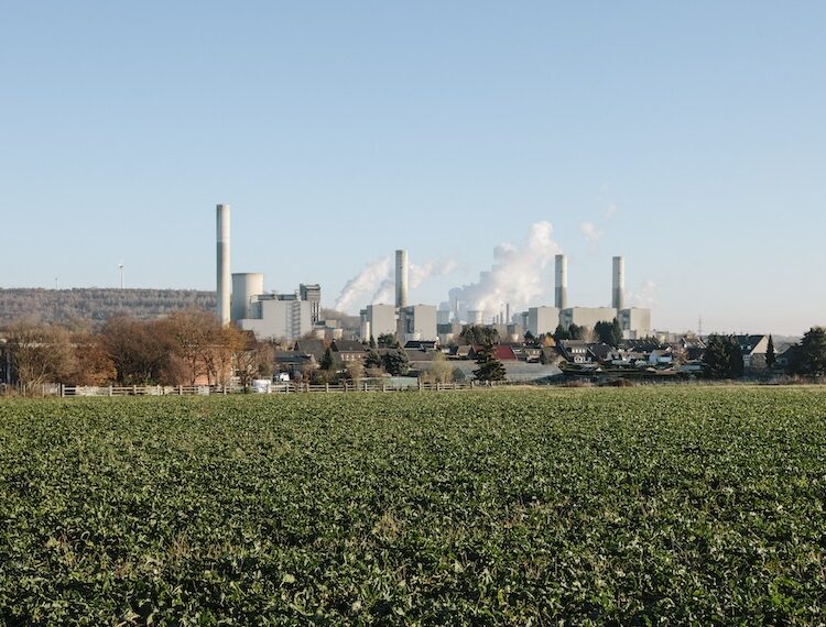 Gröna åkrar med fabrik