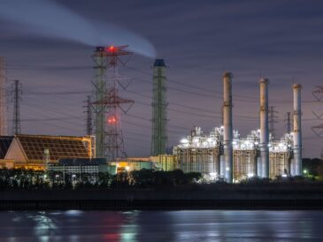 Kraftledningar och industribyggnader med digitalt nätverk och ljuspunkter