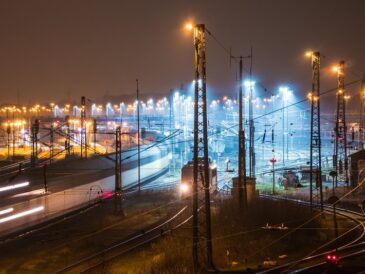 Industrianläggning med kraftledningar och rök mot kvällshimlen