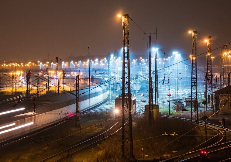 Industrianläggning med kraftledningar och rök mot kvällshimlen