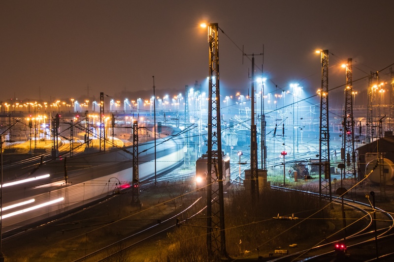 Industrianläggning med kraftledningar och rök mot kvällshimlen