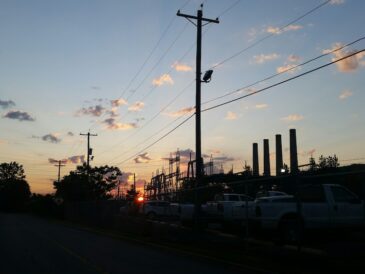 Industrianläggning vid väg med kraftledningar och upplysta processanläggningar