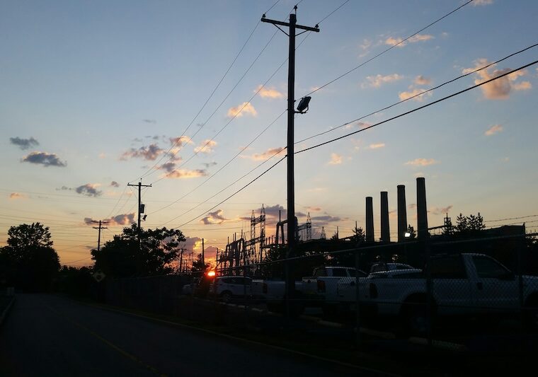 Industrianläggning vid väg med kraftledningar och upplysta processanläggningar