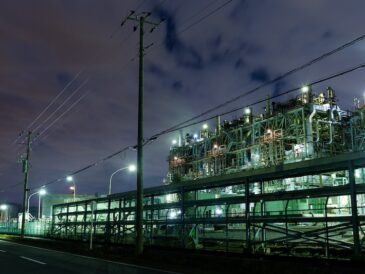 Elinfrastruktur vid järnväg och industrimiljö upplyst nattetid