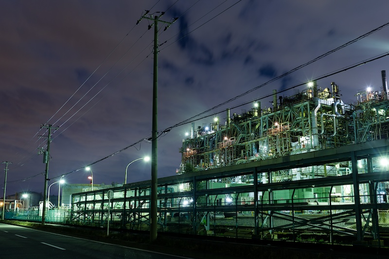 Elinfrastruktur vid järnväg och industrimiljö upplyst nattetid